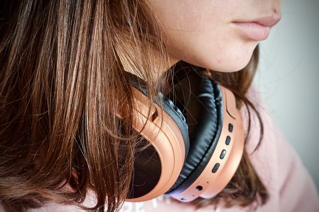 Girl wearing a pair of headphones around her neck